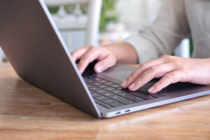 Tip on creating good content by ABX. A photo of a woman typing at a laptop.